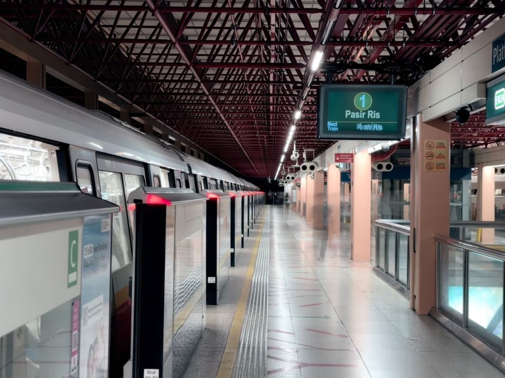 Symmetrical perspective shot of a Singapore MRT train arriving at a Downtown Line platform