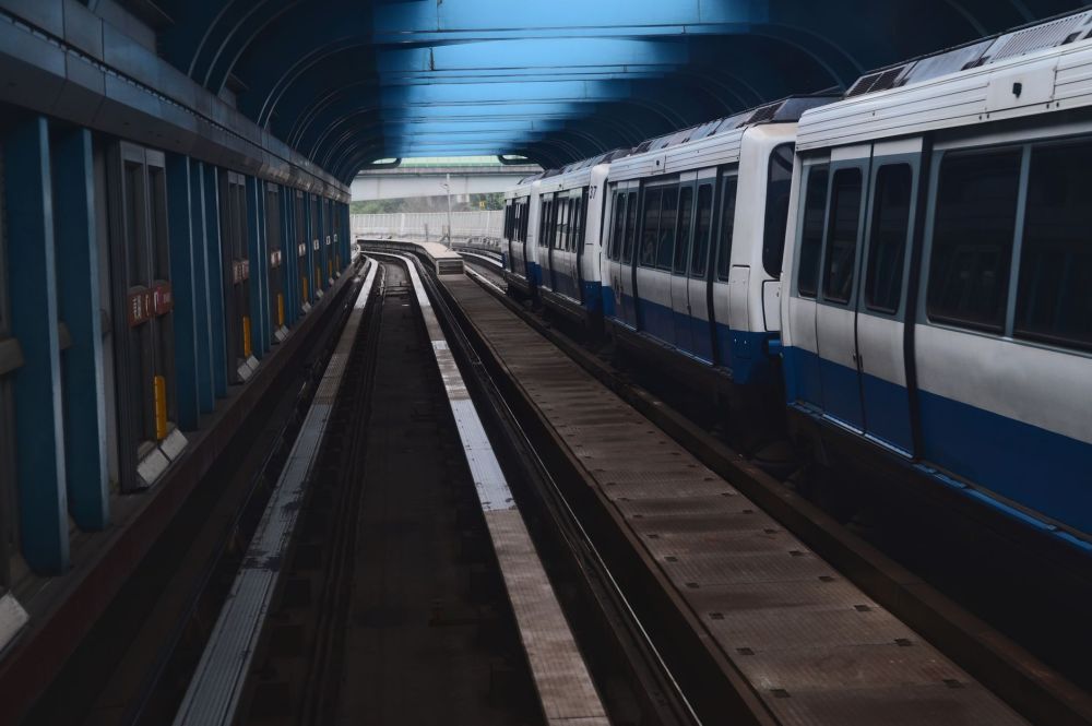 A Circle Line MRT platform with yellow safety markings and commuters waiting to board