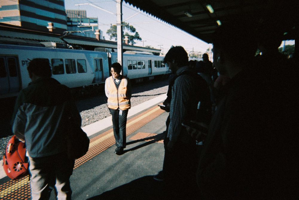 Commuters standing close together on a train platform during peak morning hours