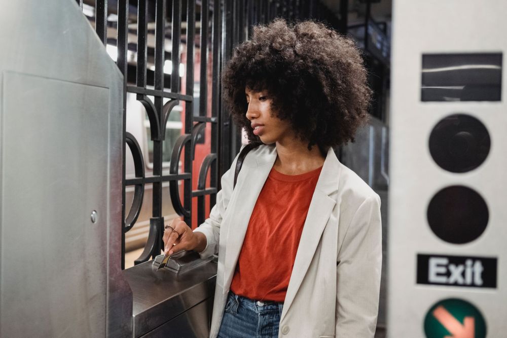 Commuters tapping cards at fare gates while entering a metro station