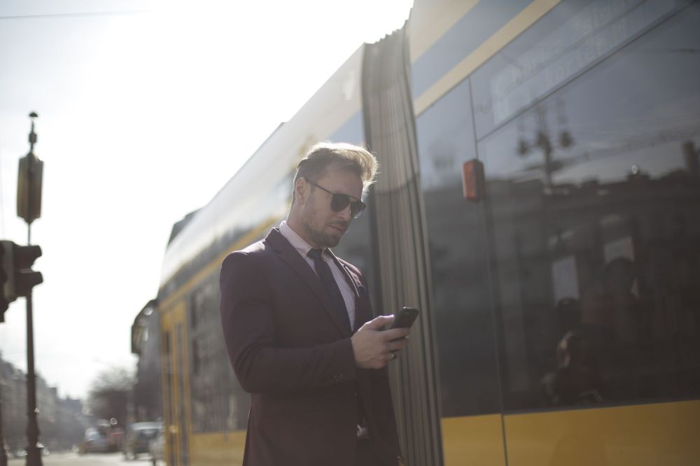 Commuter checking a phone for travel updates while waiting in a station
