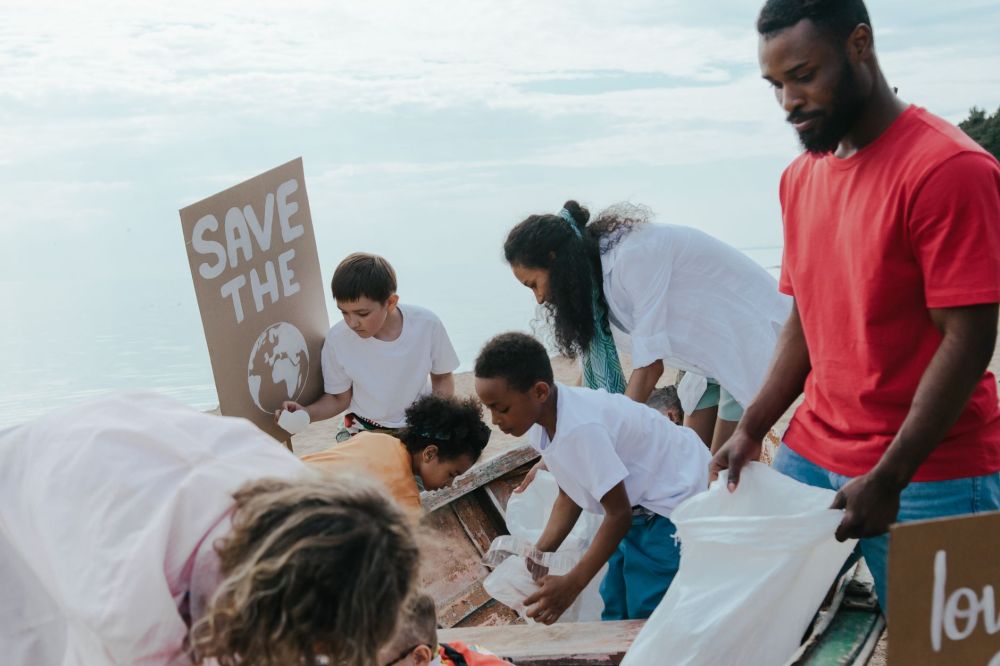 Volunteers pinning printed posters onto an outdoor noticeboard in a residential estate